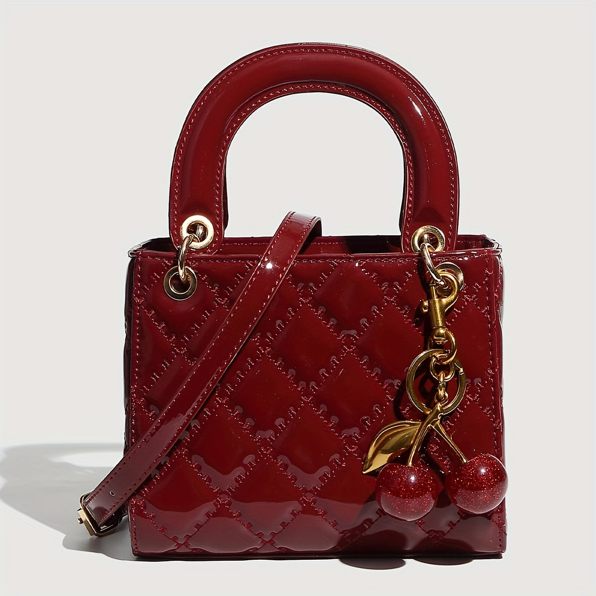 Sac à main rouge élégant avec quincaillerie dorée, fermeture magnétique et motif détaillé