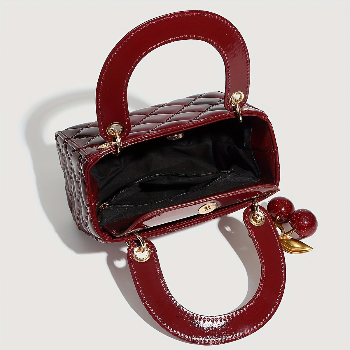 Sac à main rouge élégant avec quincaillerie dorée, fermeture magnétique et motif détaillé