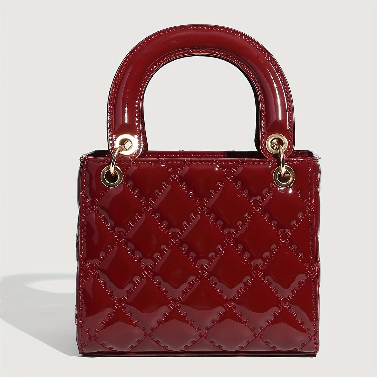 Sac à main rouge élégant avec quincaillerie dorée, fermeture magnétique et motif détaillé
