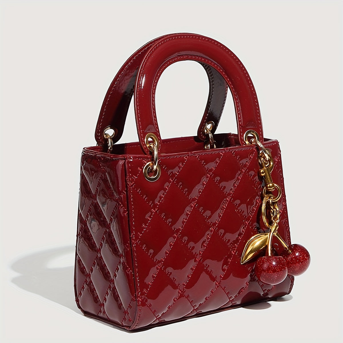 Sac à main rouge élégant avec quincaillerie dorée, fermeture magnétique et motif détaillé